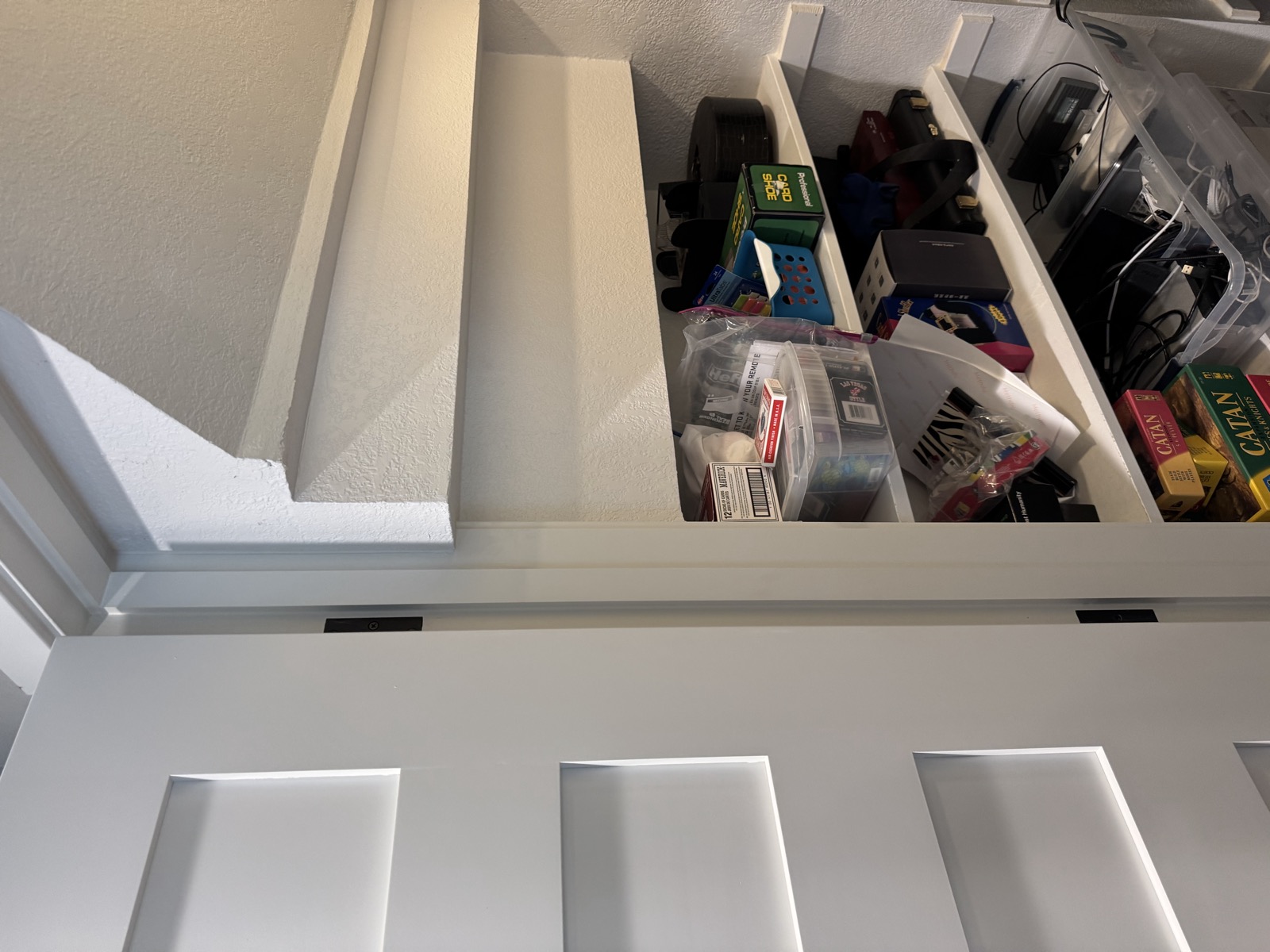The open door and the left shelf bay under the stair soffit
